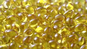 Video Golden background capsules Close up food supplement oil filled capsules suitable vitamin A, vitamin D3, fish oil, omega 3, 6, 9, evening primrose, borage oil, flax seeds oil, vitamin D, E.