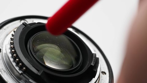 close up of cleaning the lens of DSLR camera from dust and dirt using special air blower equipment. Maintenance of electronic equipment.