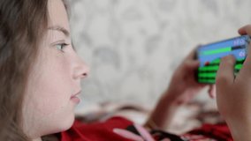 a teenage girl plays online games on a smartphone
