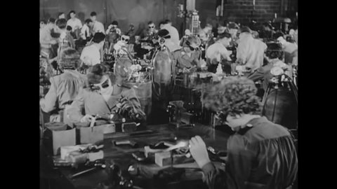 CIRCA 1940s - Men and women work in factories and production plants building war equipment and weaponry in 1942.