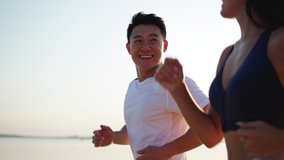 Young joyful active couple jogging together along beautiful beach. Running happy woman and man enjoying their summer morning workout. Team sports. - Powered by Shutterstock - Get 15% off with code: PIKWIZARD15