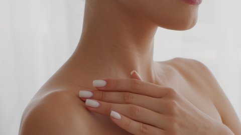 Skincare Concept. Closeup Shot Of Unrecognizable Young Nude Woman Touching Her Soft Smooth Skin In Collarbone Area, Naked Female Enjoying Her Beauty And Perfect Body, Slow Motion Footage, Cropped
