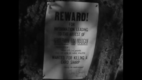 CIRCA 1936 - In this western film, an outlaw admires his wanted poster, posted to a tree.