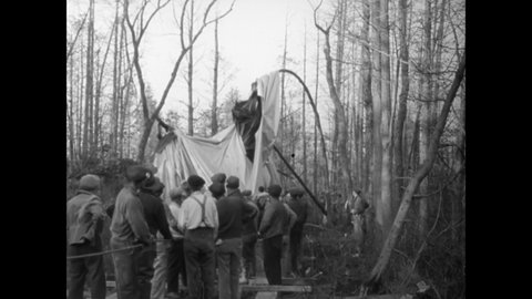 CIRCA 1941 - Men pull the ruins of a tattered hot air balloon out of some trees in New Jersey.