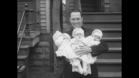 CIRCA 1931 - A couple tends to their triplet babies, bathing, feeding and taking them for a walk.