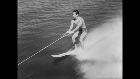 CIRCA 1952 - Men attempt waterskiing stunts, some with better success than others.