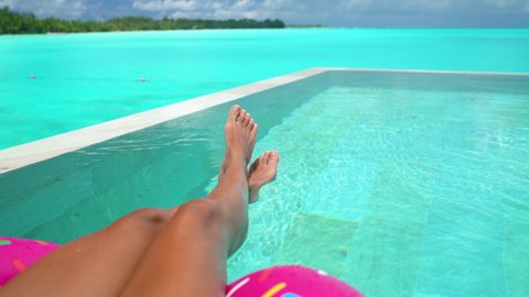 Vacation Travel Concept Video. Woman Relaxing in Swimming Pool. Legs