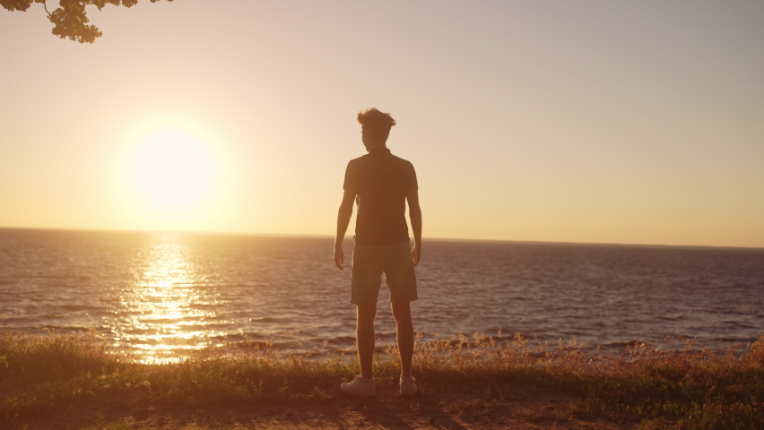 Strong man raising arms slow-mo, enjoying early morning near sea, feeling power