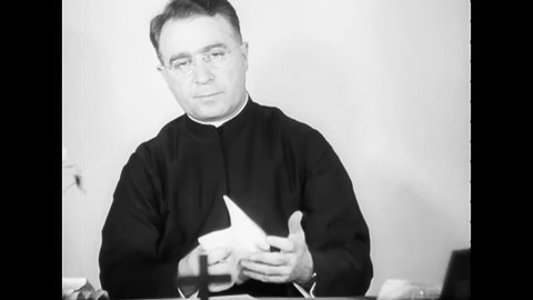 CIRCA 1930s - Father Coughlin talks on the phone and reads correspondence.