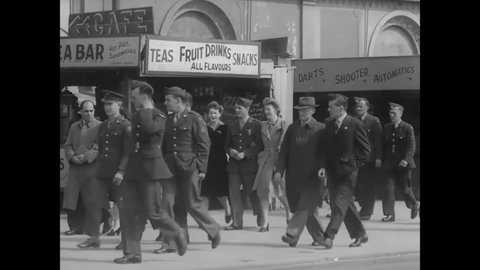 CIRCA 1940s - British soldiers walk past boardwalk games and photo booths, and flirt with civilian women.