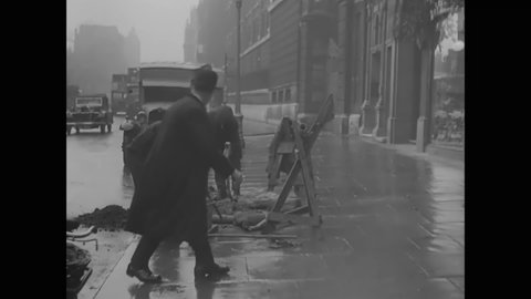 CIRCA 1930s - Men install a Belisha beacon lamp on a British city street.
