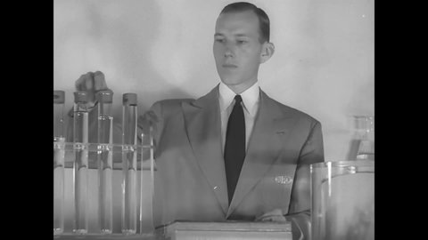 CIRCA 1940s - A DuPont scientist shows off how unbreakable and flexible the company's glassware is.