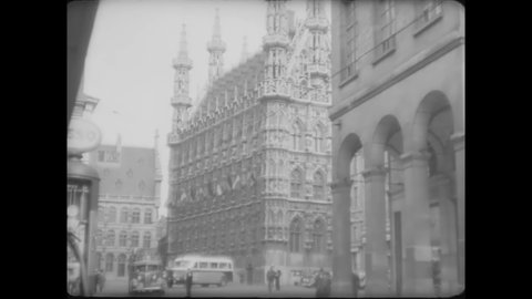 CIRCA 1930s - Streetcars pass by a cathedral in Belgium.