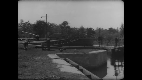 CIRCA 1930s - A canal is opened for a ferry to pass through in Belgium.