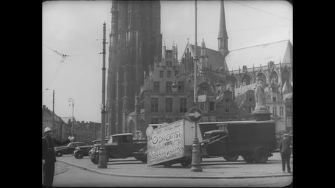 CIRCA 1930s - A traffic cop directs myriad vehicles in a Belgian city.