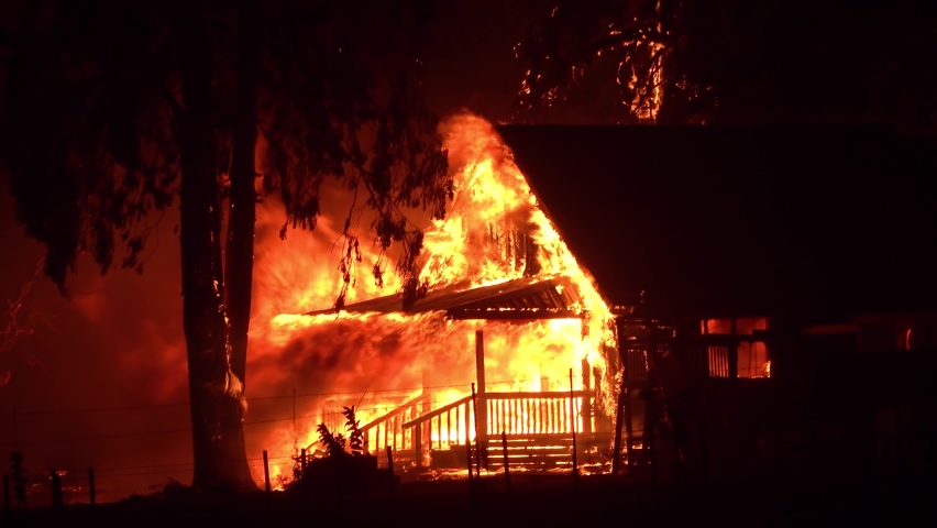NORTHERN CALIFORNIA - CIRCA 2021 - A house is engulfed in flames at night during the disastrous Dixie Fire in Northern California.