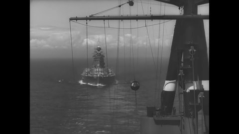 CIRCA 1940s - A British Naval fleet sails past a port.