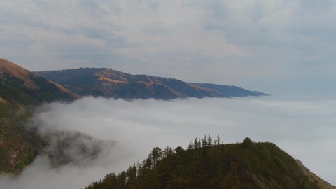 BIG SUR, CALIFORNIA - CIRCA 2021 - Beautiful aerial of fog rolling into the coast of California near Big Sur.