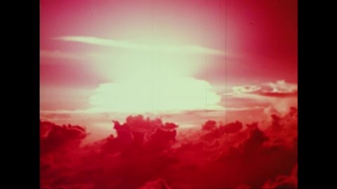 CIRCA 1950s - The mushroom cloud from an atomic bomb test explodes in a red sky.