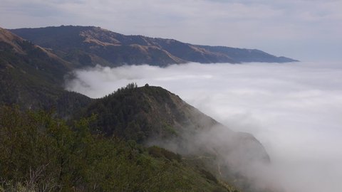 BIG SUR, CALIFORNIA - CIRCA 2021 - Fog rolls into the coast of California near Big Sur in this dramatic timelapse shot.