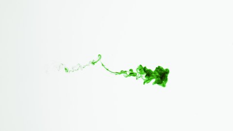 Super slow motion isolated Green Ink Cloud floating in clear water. Macro Slow Motion Shot on White Background with selective focus framed for vertical, horizontal video and compositing plate.