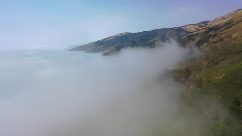 BIG SUR, CALIFORNIA - CIRCA 2021 - Beautiful aerial shot through the fog reveals the remote mountains along California's Highway One.
