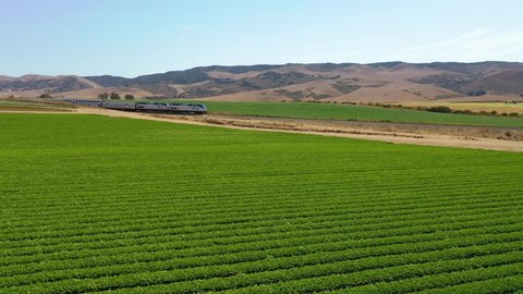 MARTINEZ, CALIFORNIA - CIRCA 2021 - Aerial of Amtrak passenger train traveling through generic California farm country near Martinez, California.
