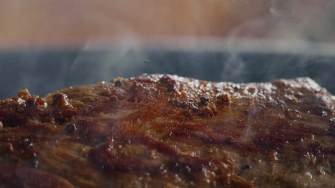 Close up Seasoning with Falling Herbs on Fresh Fried Pork Meat. Best Slow Motion Shot Professional Cooking. Spectacular images from kitchen.