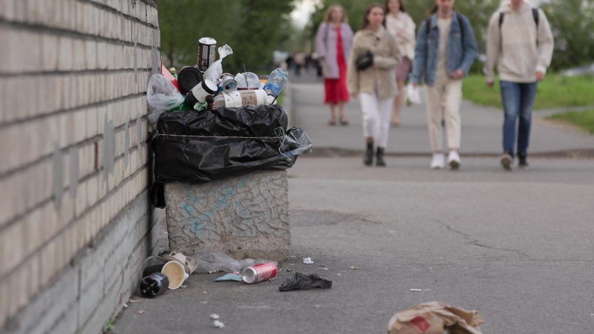 Garbage, people throw out garbage, full bins, garbage lying on the streets of the city. people walk past garbage | Shutterstock HD Video #1078038722