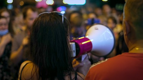 Demonstration of feminism riot protester. Feministic woman activist megaphone on picket march. Female feminist speaks with bullhorn in protest crowd march on political rally. Feminized girl revolt.
