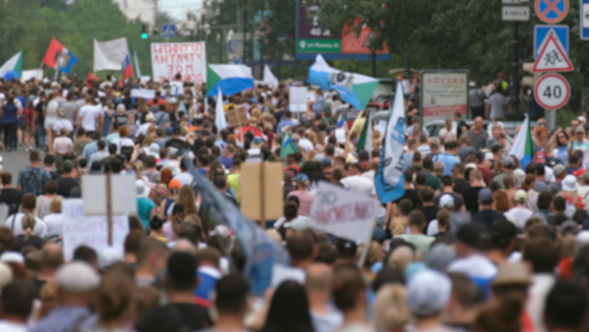 Protest people crowd on political riot in Russia marching on city streets, peaceful non-violent demonstration rally. Crowded protesters march with banners, placards, posters and signs on picket strike Royalty-Free Stock Footage #1078049105