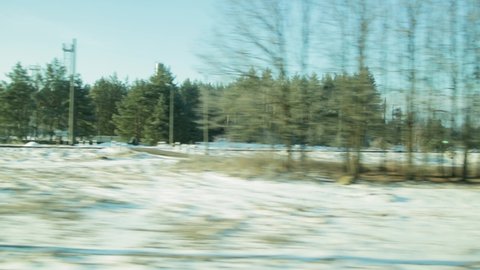 View from the train window while driving on the countryside and the village. Spring time, thawed patches with snow, background. Landscape
