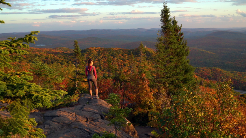 Autumn Fall Foliage Colorful Forest with Woman Walking on Travel Hike Looking at Stunning View. Hiking woman on mountain forest summit n Mont Tremblant, Laurentians, Quebec, Canada