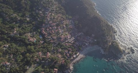 Aerial drone view of beach front and  coastline of Sant Andrea on the island of Isola d'elba during sunset, Italy