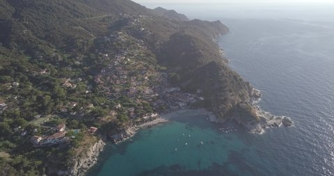 Aerial drone view of beach front and  coastline of Sant Andrea on the island of Isola d'elba during sunset, Italy