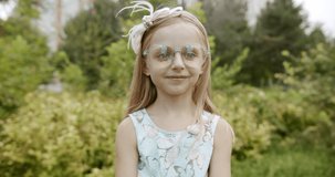little girl smiling with glasses give the gift box and smiling on park nature
