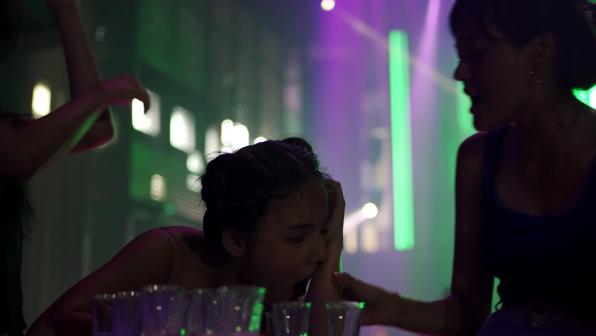 4K Group of Beautiful Asian woman dancing to the music with drinking alcoholic drink on table at night club. Pretty girl friends enjoy and having fun nightlife crazy dance together at nightclub party
