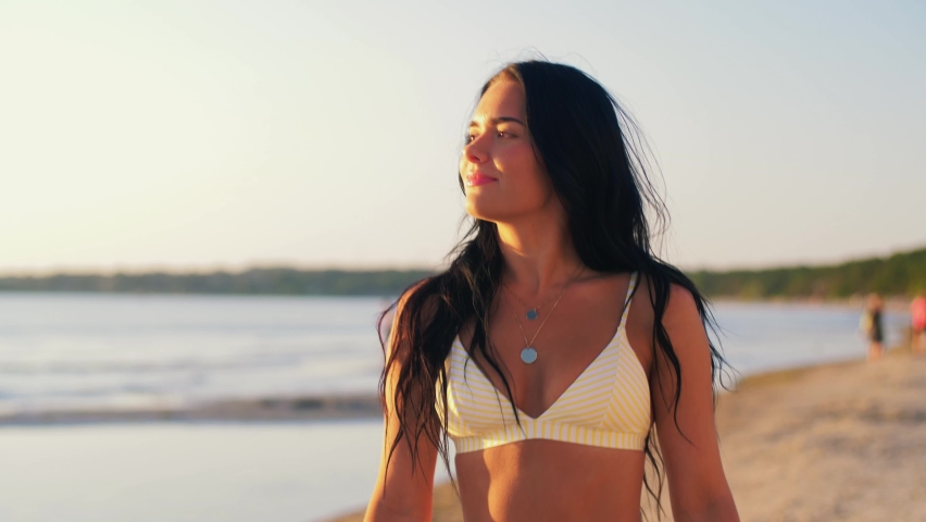 people, summer and swimwear concept - happy smiling young woman in bikini swimsuit on beach