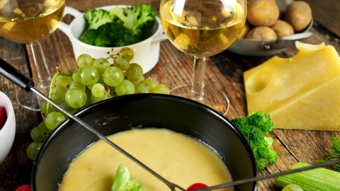 cheese fondue with vegetables and glasses of wine