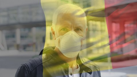 Belgium waving flag against portrait of caucasian senior man wearing face mask on the street. coronavirus covid-19 pandemic concept