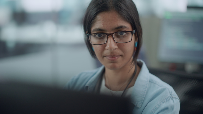 Diverse Office: Portrait of Confident Indian IT Programmer Working on Desktop Computer. Female Specialist Wearing Glasses Create Innovative Software. Professional Engineer Develop Inspirational App