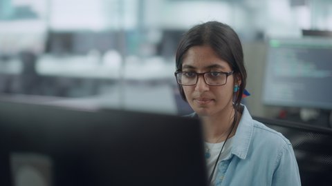 Diverse Office: Portrait of Beautiful Indian IT Programmer Working on Desktop Computer. Female Specialist Wearing Glasses Create Innovative Software. Professional Engineer Develop Inspirational App