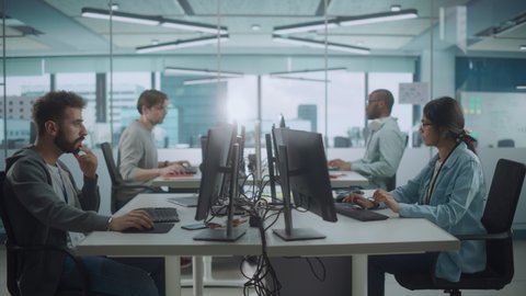 Diverse Multi-Ethnic Team Working in Big City Office: IT Programmers Working on Desktop Computers. Specialists Creating Innovative Software. Engineers Developing Inspiration App, Program. Wide Shot