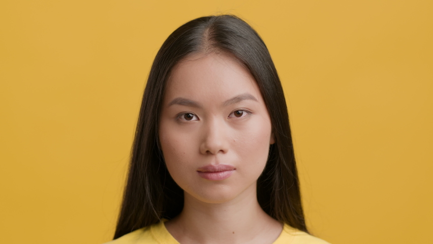 Disgust Emotion. Asian Woman Frowning Feeling Bad Smell Shaking Head In Disapprovement Posing Over Yellow Studio Background. Portrait Of Disgusted Female Smells Unpleasant Smelly Stink | Shutterstock HD Video #1078083401