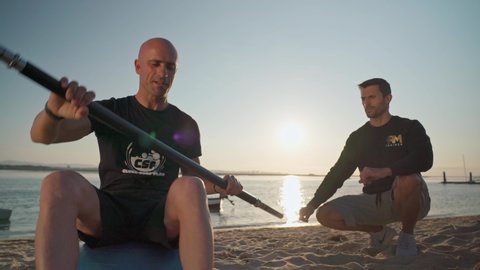 An athlete on the beach, trains in canoeing and receives instructions from a personal fitness trainer. On the bosu ball. Portugal Faro 2021 March 15 