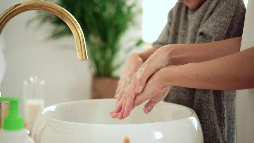 Washing hands with antibacterial soap. Spbd Little kid girl with lady parent rub diligently foamy palms above elegant vessel sink in light bathroom closeup Royalty-Free Stock Footage #1078092938