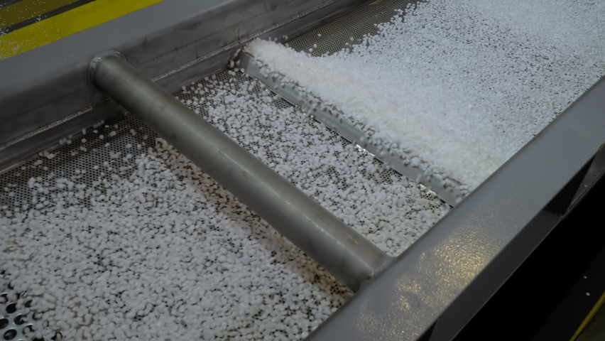 Propylene or polyethylene pellets - recycled plastic granules on conveyor belt, shale shaker of waste plastic recycling machine. Environmental protection, automated technology, separation concept | Shutterstock HD Video #1078096949