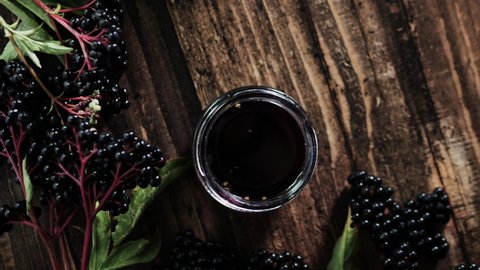 Natural elderberry juice top view. Black elderberry berry on a wooden background. Herbal medicine