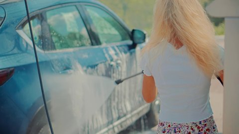 Car Cleaning And Waxing Vehicle.Dirty Car Cleaning And Protection With Active Foam. Clean Water Spray Pressure. Woman Washing Car On Wash Self-Service. Washes Automobile Active Foam And Osmosis Water.