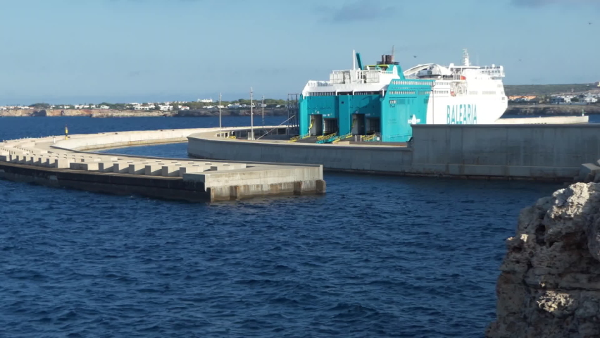 Large ferry of the Balearia company waiting in the port of Ciutadella on the island of Menorca in Spain, sunny day.